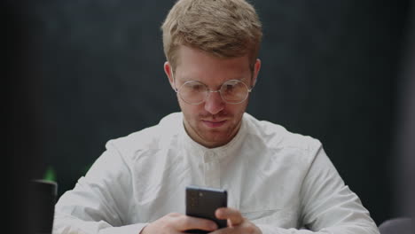 portrait-of-man-with-smartphone-in-hands-male-user-is-using-new-app-in-mobile-phone-tapping-and-scrolling